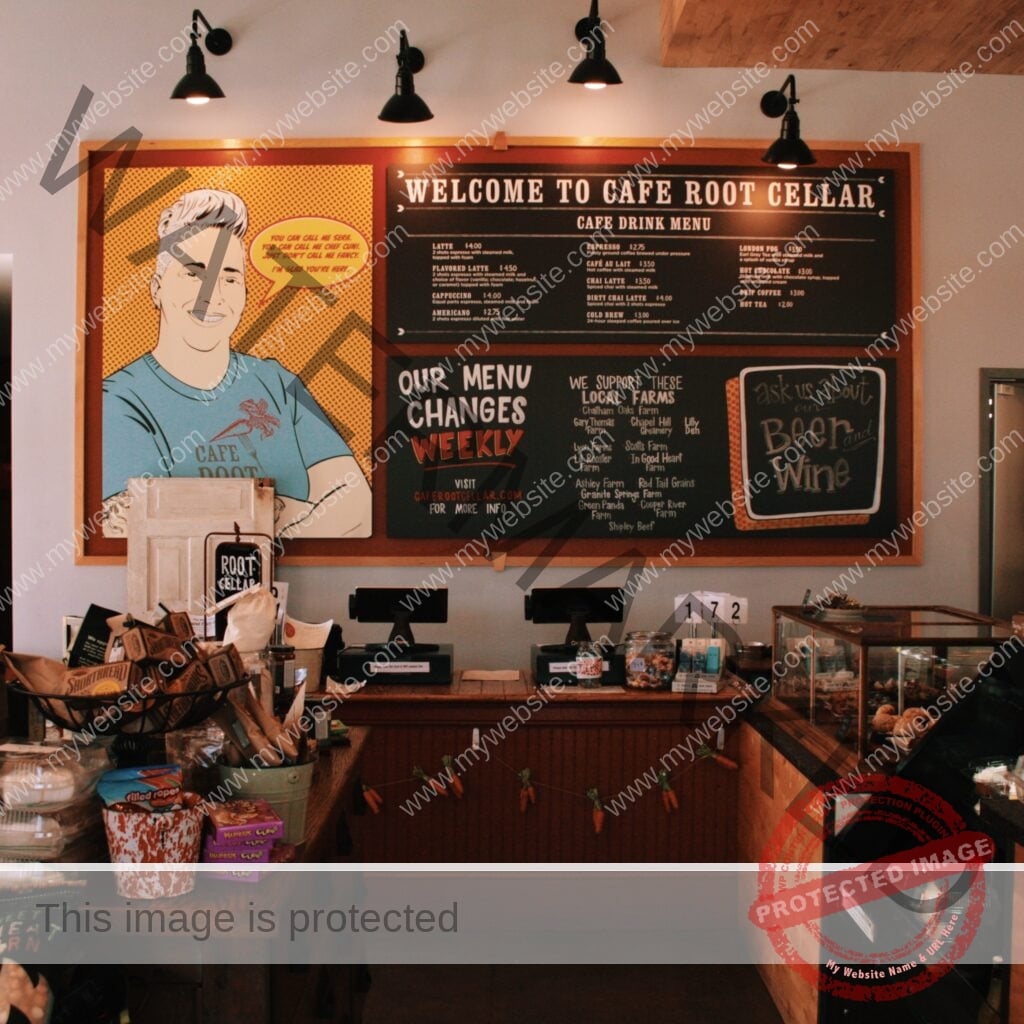 The counter-service area inside Cafe Root Cellar. Above the wood counter hangs a large framed board reading "Welcome to Cafe Root Cellar" with a handwritten café drink menu listing lattes, espresso, cappuccino, chai, cold brew, and more. To the left, a colorful pop-art-style mural depicts Chef Sera Cuni in a teal "Cafe Root Cellar" T-shirt with a speech bubble reading, "You can call me Sera. You can call me Chef Cuni. Just don't call me fancy. I'm glad you're here." A chalkboard section notes "Our menu changes weekly" and lists supported local farms alongside a "Beer and Wine" prompt. The counter holds point-of-sale tablets, packaged retail snacks and baked goods, a tip jar, and a glass pastry case, with a garland of small fabric carrots strung across the front.