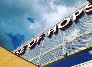 Worm's eye view of the red and white Pittsboro House of Hops sign as you enter the bottle shop. 