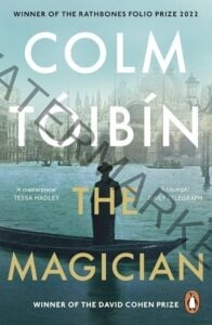 Book cover for "The Magician" by Colm Tóibín, winner of the Rathbones Folio Prize 2022 and the David Cohen Prize. A lone silhouetted figure in a hat and long coat stands in a gondola on flooded Venetian streets, with the facade of St. Mark's Basilica visible in the misty background. Blurbs read "A masterpiece" — Tessa Hadley, and "A triumph" — Daily Telegraph.