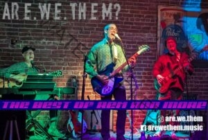 Promotional image for the band "are.we.them?" showing three musicians performing on a small stage against an exposed brick wall with a vintage Pabst Blue Ribbon sign. Left: a person in a ball cap playing acoustic guitar behind a Casio keyboard. Center: a singer in a green patterned shirt playing a blue electric guitar at the microphone. Right: a bassist in a red shirt. A purple banner across the bottom reads "The Best of REM and More," with Instagram handle @are.we.them and Facebook handle arewethem.music.