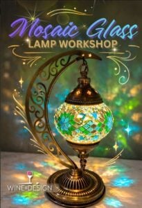 Promotional flyer for a Mosaic Glass Lamp Workshop hosted by Wine & Design. The title "Mosaic Glass Lamp Workshop" appears at the top in purple-blue script and gold block lettering, surrounded by sparkle and starburst illustrations on a softly glowing teal-and-gold background. The centerpiece is a finished example: an ornate Turkish-style mosaic lamp with a globe of turquoise, green, and gold glass tiles, illuminated from within, suspended from a filigree brass crescent-moon stand on a marble surface. The Wine & Design logo (a red wine glass with the brand name) sits in the bottom left corner.
